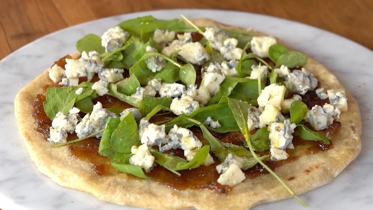 Piadina de queso azul, cebollas caramelizadas y rúcula